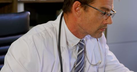 Doctor Focusing on Paperwork in Modern Clinic - Download Free Stock Images Pikwizard.com