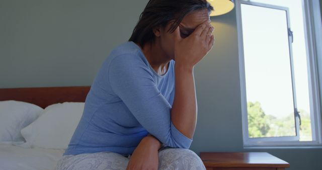 Stressed Woman Sitting on Bed Covering Face with Hand Indoor - Download Free Stock Images Pikwizard.com