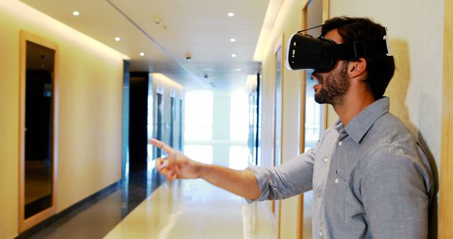 Man Using Virtual Reality Headset in Modern Office Hallway - Download Free Stock Images Pikwizard.com