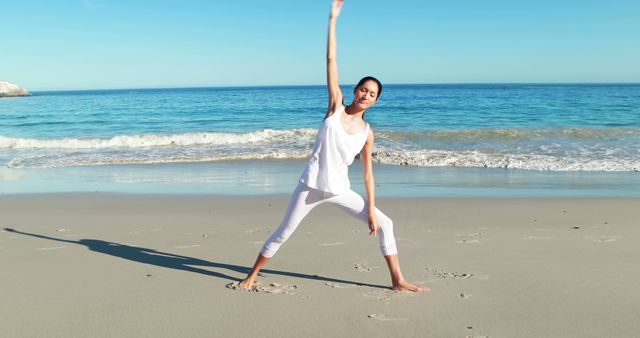 Woman practicing yoga stretch on beach, demonstrating fitness and wellness. Perfect for use in health and wellness websites, advertisements for yoga and fitness retreats, articles on the benefits of exercising in nature, and inspirational social media content related to healthy living.