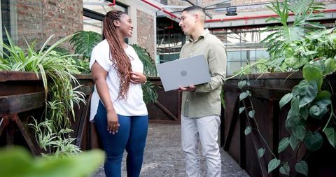 Colleagues Collaborating with Laptop in Modern Office Environment