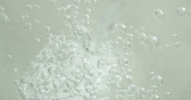 Bubbles form vigorously in clear water, indicating movement or a reaction taking place. Such imagery is often associated with concepts of purity, cleanliness, or scientific processes.