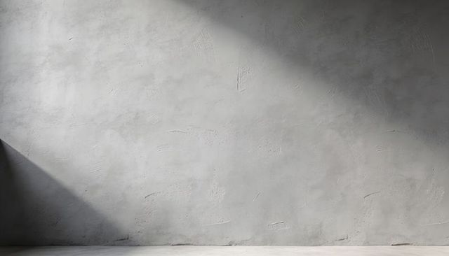 Minimalist plaster wall with trowel texture and diagonal shadow in industrial interior