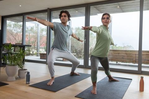 Friends Practicing Warrior II Pose in Modern Home Workout Space