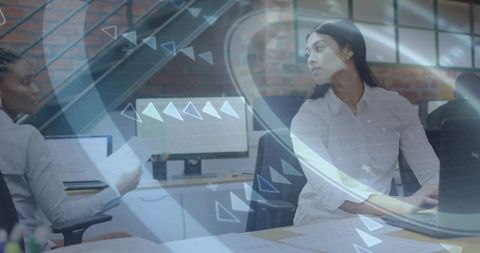 Collaborating colleagues reviewing laptop with digital HUD overlay in open-plan office