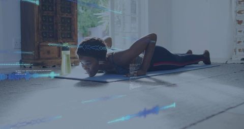 Woman performing plank on blue mat with digital workout overlay and yellow water bottle