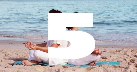 Couple meditating back-to-back on sandy beach with bold number 5 overlay for wellness campaign