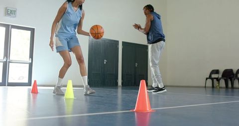 Coach Guiding Athlete in Basketball Dribbling Practice