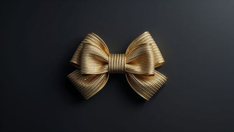 Luxury metallic gold ribbon bow on dark surface