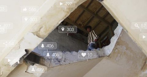 Young man peering from crumbling building with floating social media notifications