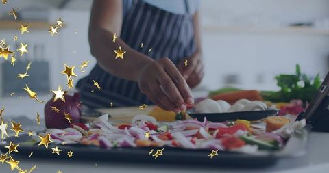 Home cook seasoning colorful vegetable tray for roasting using tablet recipe and fresh produce