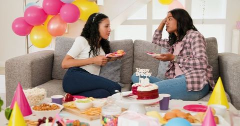 Women Celebrating Birthday Laughing Together on Sofa