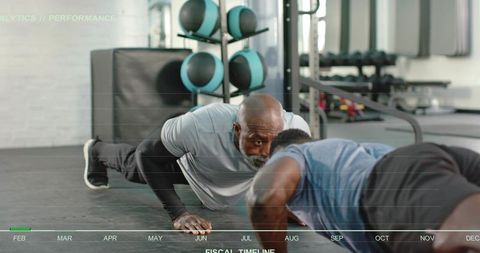 Personal trainer guiding client through push-ups during functional gym performance session