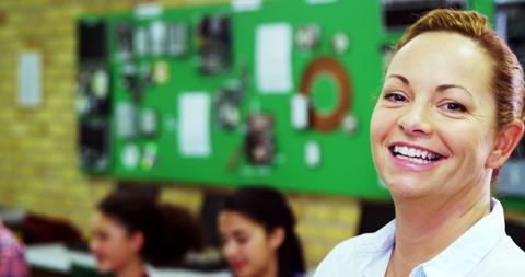 Smiling Teacher in Vibrant Classroom Environment with Engaged Students