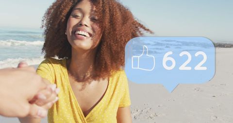 Joyful woman receiving social media likes by the beach