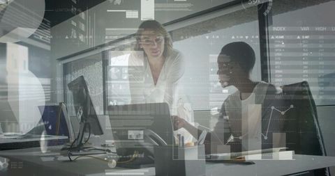 Two Businesswomen Collaborating Over Data Analytics and Interactive Charts in Modern Office