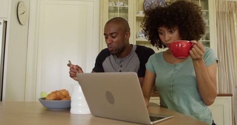Couple Enjoying Breakfast and Online Communication in Kitchen