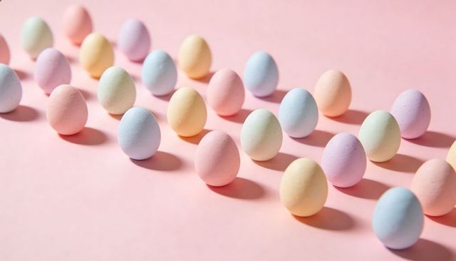 Pastel easter eggs arranged in diagonal rows on pink backdrop with soft shadows for spring