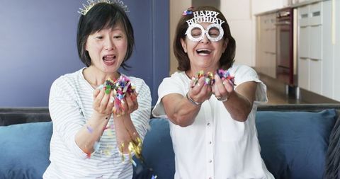 Senior Women Enjoying Birthday Celebration with Confetti Indoors
