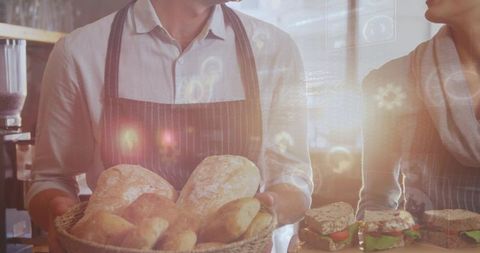 Artisan Bakers Presenting Fresh Bread and Sandwiches Behind Sunlit Cafe Counter