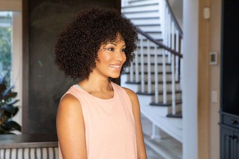 Smiling African American Woman by Staircase in Modern Home