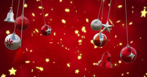 Festive hanging christmas baubles with glittering stars on red background