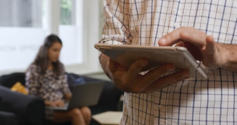 Caucasian Man Using Tablet in Creative Office with Female Colleagues