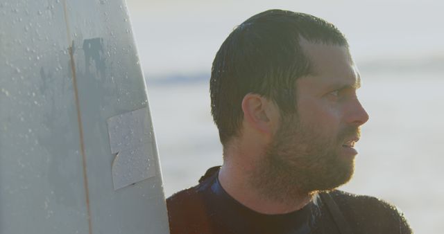 Surfer Gazing Steadily While Holding Surfboard at Beach - Download Free Stock Images Pikwizard.com