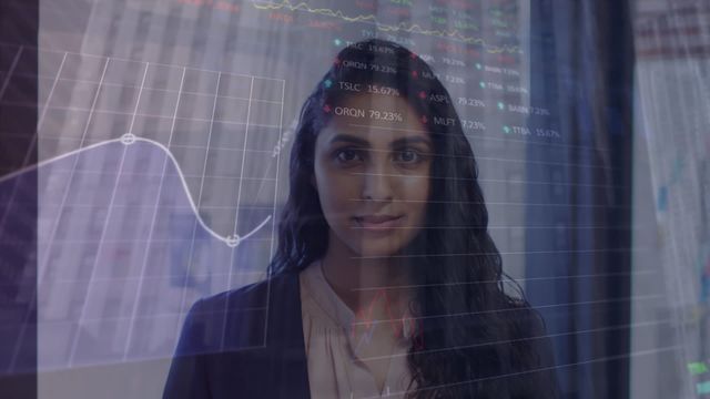 Professional Indian woman at office smiling while stock market data and charts overlay her image, conveying a combination of financial analytics and modern business environment. Suitable for illustrating business technology, financial analysis, professional success and diversity in financial sectors.