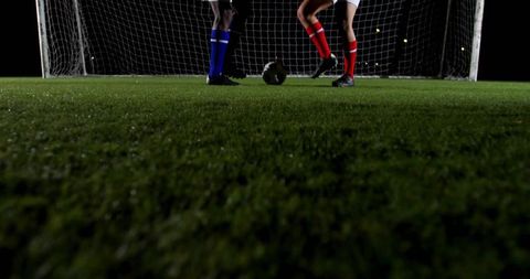 Nighttime Soccer Duel at Goal Mouth on Turf with Cleats and Ball, Competitive Action