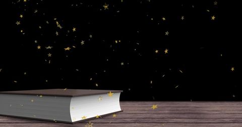 Falling gold stars over book on wooden table