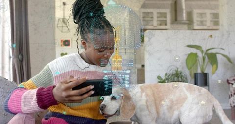 Smiling Woman Bonding with Beagle and Exploring Smart Technology at Home
