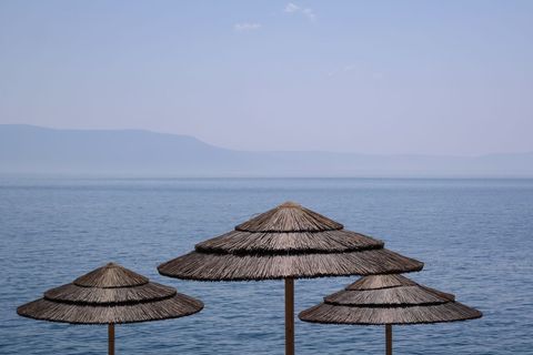 Tranquil mediterranean beach with wicker umbrellas