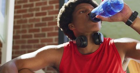 African american man hydrating after home workout