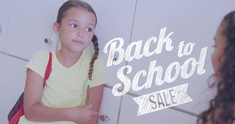 Schoolgirls conversing by lockers with back to school sale