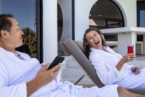 Senior couple enjoying relaxation on spa terrace with drinks