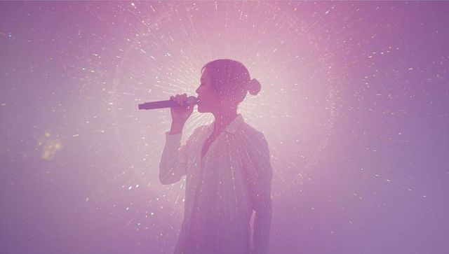 Solo Female Singer on Neon Stage with Cosmic Light Display