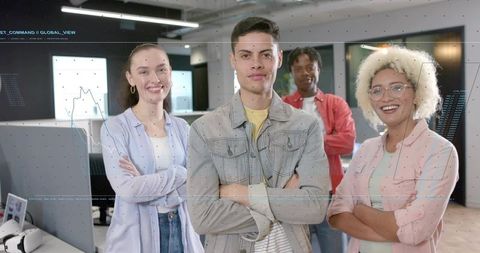 Confident young professionals standing with arms crossed in modern office with analytics overlay