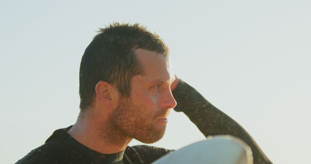 Surfer Man Pondering at Beach With Wet Black Wetsuit - Download Free Stock Images Pikwizard.com