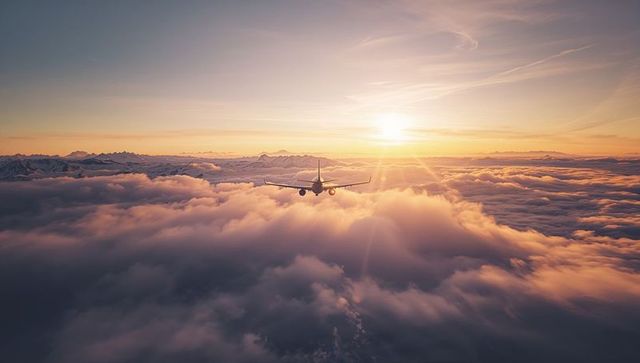 Jetliner Soaring Through Sunrise Clouds