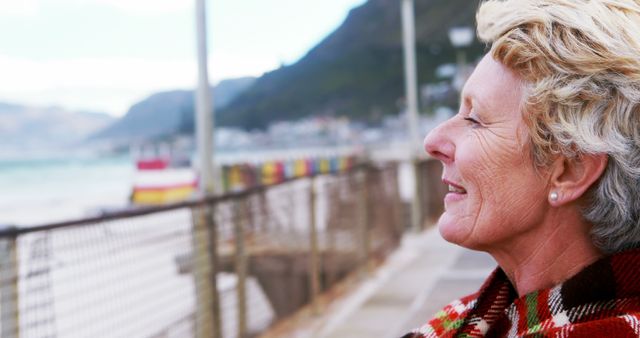 Senior Woman Enjoying Ocean Breeze at Beachfront - Download Free Stock Images Pikwizard.com