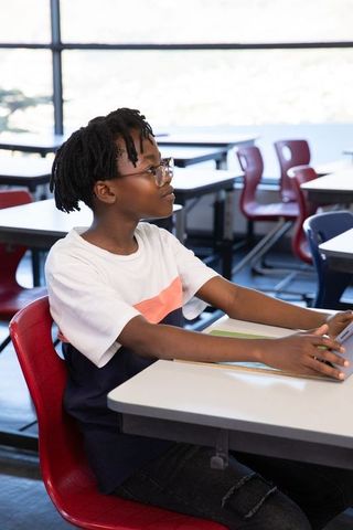 Teen Sitting in Classroom Using Digital Tablet