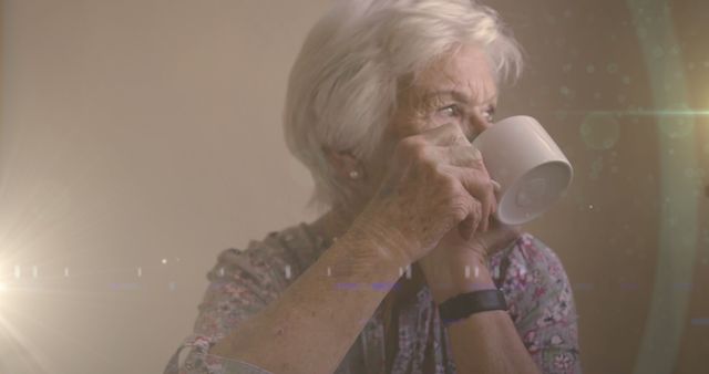 Elderly woman holding coffee mug, appearing thoughtful and contemplative, dressed casually. Ideal for themes of aging, reflection, peaceful moments, daily routines, elderly care, lifestyle, senior living.
