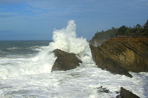 Ocean Waves Crashing Against Jagged Coastal Cliffs with Spray Soaring