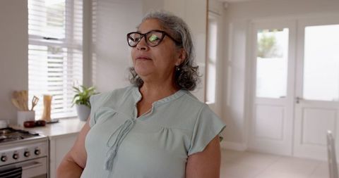 Elderly Woman Enjoying Relaxation with Coffee at Home Kitchen