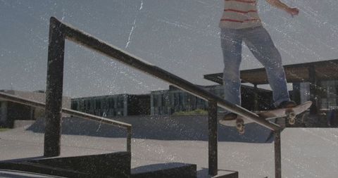 Young Male Skateboarder Grinding on Metal Rail at Urban Skate Park