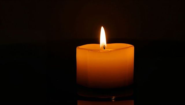 Warm Amber Candle Flame with Melted Wax and Soft Reflective Glow, Serene Minimalist Composition