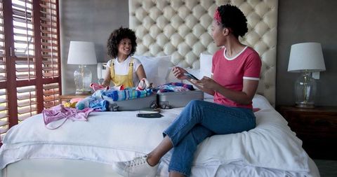 Cheerful Couple Packing Suitcase for Vacation at Home