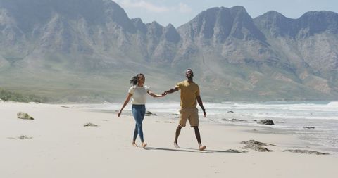 Couple Enjoying Beach Walk in Scenic Mountainous Landscape