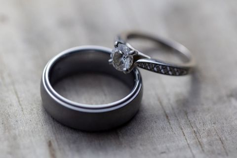 Closeup of Diamon Engagement and Wedding Rings on Wooden Surface